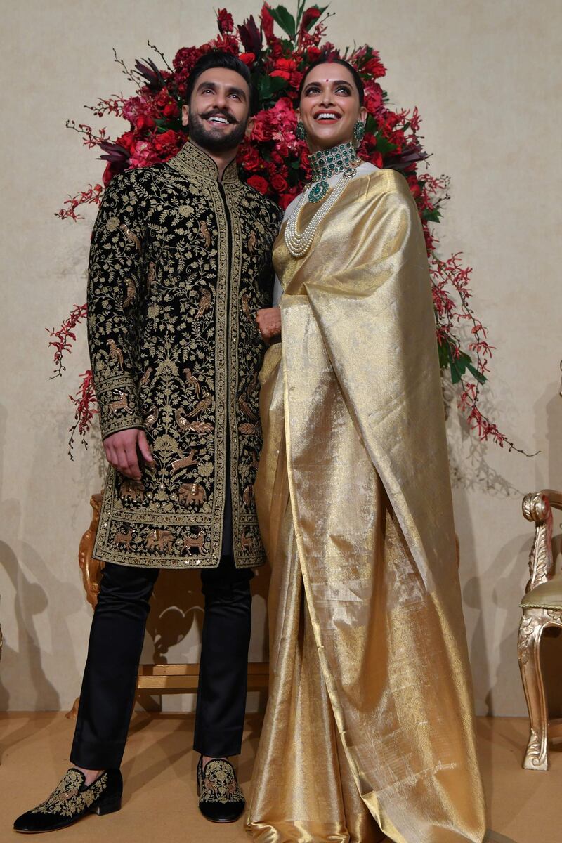 Indian Bollywood actors Ranveer Singh (L) and Deepika Padukone pose for photographers during their wedding reception held at the Leela Palace in Bangalore on November 21, 2018.

 The couple tied the knot in a private family affair held in Italy on November 14 and 15. / AFP / MANJUNATH KIRAN
