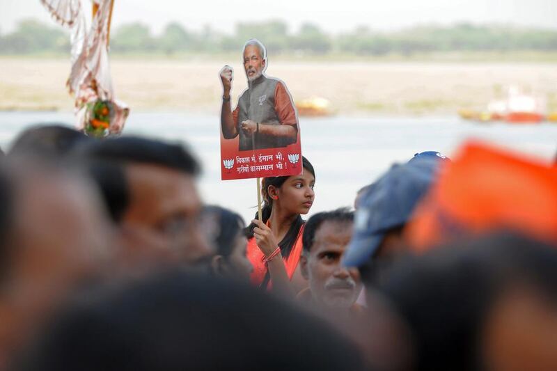 A young Indian girl holds up a placard bearing the portrait of Indian prime minister-elect Narendra Modi ahead of his arrival in Varanasi, India. Manjunath Kiran / AFP