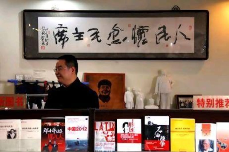 Fan Jinggang, the general manager of the neo-Maoist "Utopia" website and bookstore, stands in front of small statues of the former Chinese leader Mao. Mr Fan says China has turned its back on the ideals on which it was founded.