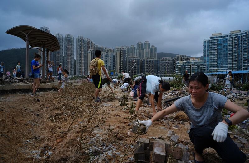 People clean debris from Typhoon Mangkhut on the waterfront in Hong Kong. AP Photo