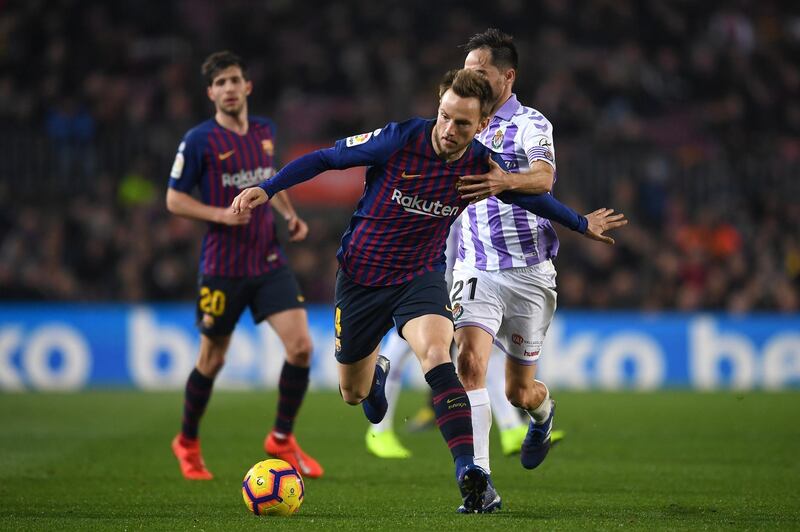 Barcelona's Ivan Rakitic is challenged by Real Valladolid's Michel. Getty Images