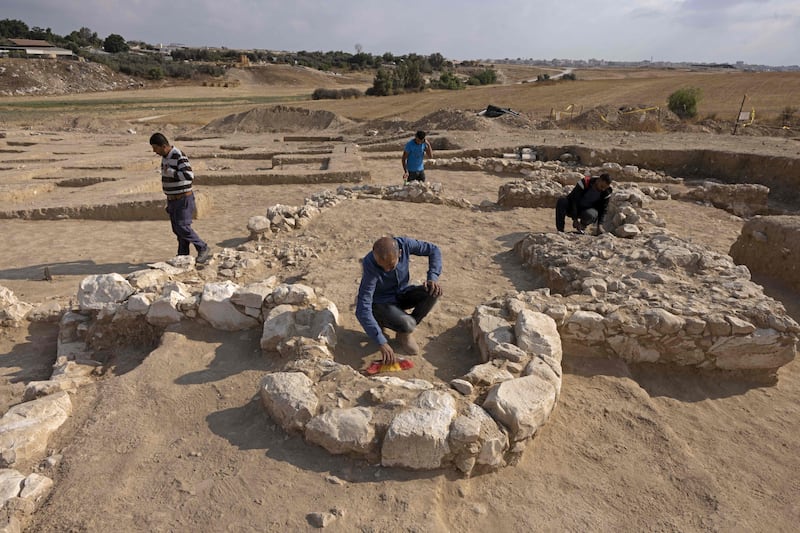 Palestinian workers of Israel's Antiquities Authority are pictured at around the remains of a recently discovered ancient mosque, which dates back to the early Islamic period, in the Bedouin town of Rahat in Israel's southern Negev desert on June 22, 2022.  - The discovery of the site, which dates back to the period between the seventh and eighth centuries, was made in a few years ago during extensive archeological excavations conducted by the Israel as part of a plan to expand southern Rahat with state funding, through the Bedouin Development and Settlement Authority in the Negev.  (Photo by MENAHEM KAHANA  /  AFP)