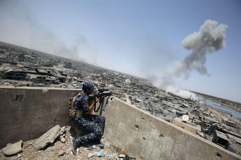TOPSHOT - An Iraqi forces sniper looks on as smoke billows, following an airstrike by US-led international coalition forces targeting Islamic State (IS) group, in the Old City of Mosul on July 9, 2017, as their part of the battle has been declared accomplished, while other forces continue to fight Islamic State (IS) jihadists in the city.
Iraq will announce imminently a final victory in the nearly nine-month offensive to retake Mosul from jihadists, a US general said Saturday, as celebrations broke out among police forces in the city. / AFP PHOTO / Ahmad al-Rubaye