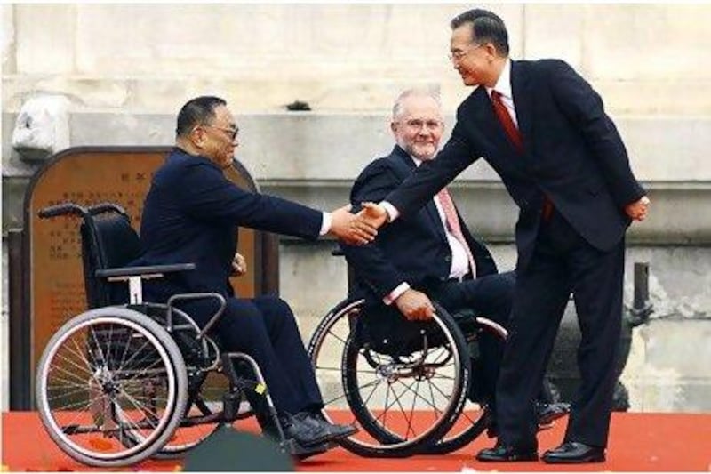 Chinese Premier Wen Jiabao, right, shakes hands with Deng Pufang, left, the President of the China Disabled Persons' Federation and son of late leader Deng Xiaoping during the Beijing 2008 Paralympic Games torch lighting ceremony in Beijing.