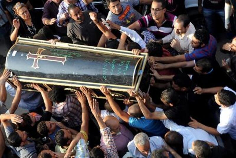 Egyptian Coptic Christians gather next to the coffin of one of the protesters killed during clashes the day before.