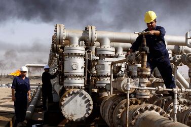 FILE - In this Dec. 13, 2009 file photo, Iraqi laborers work at the Rumaila oil refinery in Zubair near the city of Basra, Iraq. Iraq's Oil Ministry says Iraq has resumed exports from its oil fields around Kirkuk, one year after the city was seized by federal forces from the autonomous Kurdish administration in the north of the country. (AP Photo/Nabil al-Jurani, File)