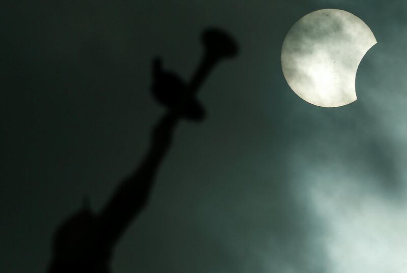 The Anjo Moroni statue atop the church of the Mormons is photographed while the solar eclipse is seen in Manaus, Brazil. Bruno Kelly / Reuters