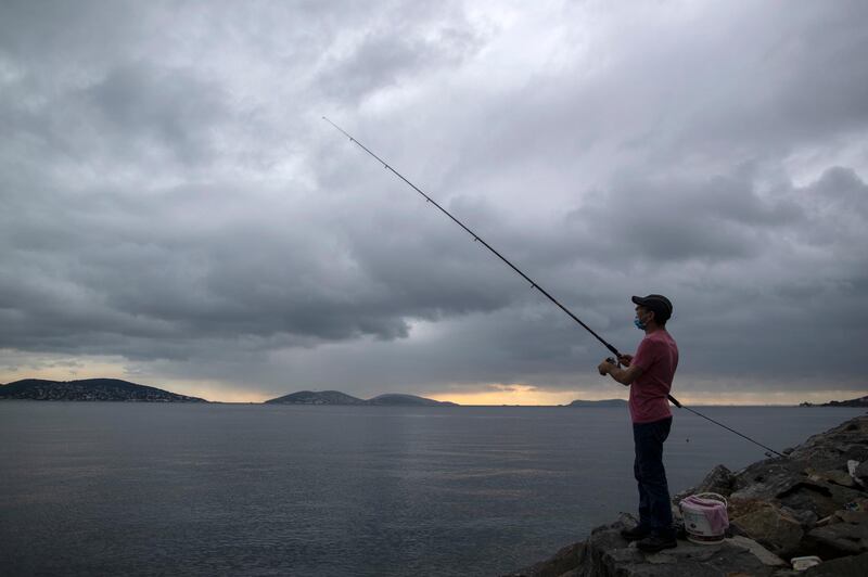A man fishes near the Marmara sea against the backdrop of Prince Islands in Istanbul, Turkey.  EPA