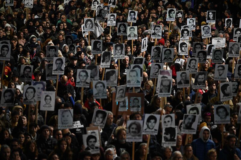 People hold portraits of those who disappeared during the last dictatorship (1973-1985) in Uruguay during the Marcha del Silencio (March of Silence) in Montevideo. AFP
