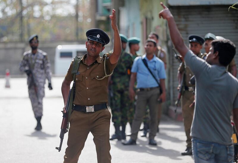 Police clear the area while bomb squad officers inspect the site of an exploded van. Reuters