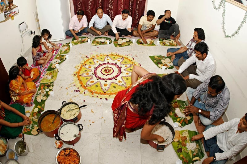 DUBAI, UNITED ARAB EMIRATES - August 29, 2012- Guests to Vivek Anand's home enjoy an Onam celebration dinner that includes Pappad, mixed vegetables with yogurt, snake gourd, Ashguard (white pumpkin) with coconut milk, sweet ripe mango curry, banana and rice chips and other traditional dishes in Abu Hail, Dubai, August 29, 2012. (Photo by Jeff Topping/The National) 