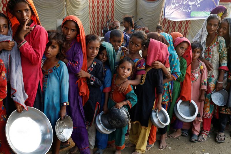 Flood victims gather to collect after rains and floods during the monsoon season in Sehwan, Pakistan. Reuters