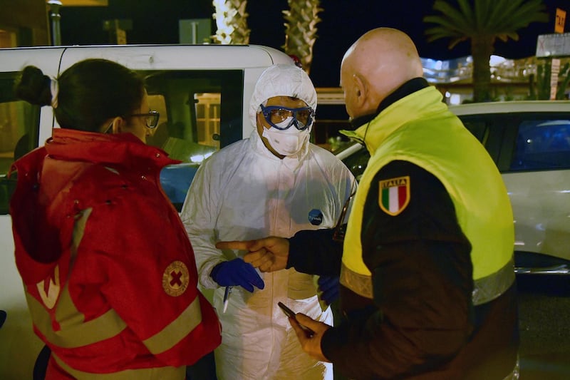 Civil protection and health workers who wear protective suits and health masks deliver the evening meal at a  hotel in Alassio where 34 people are in quarantine.  EPA