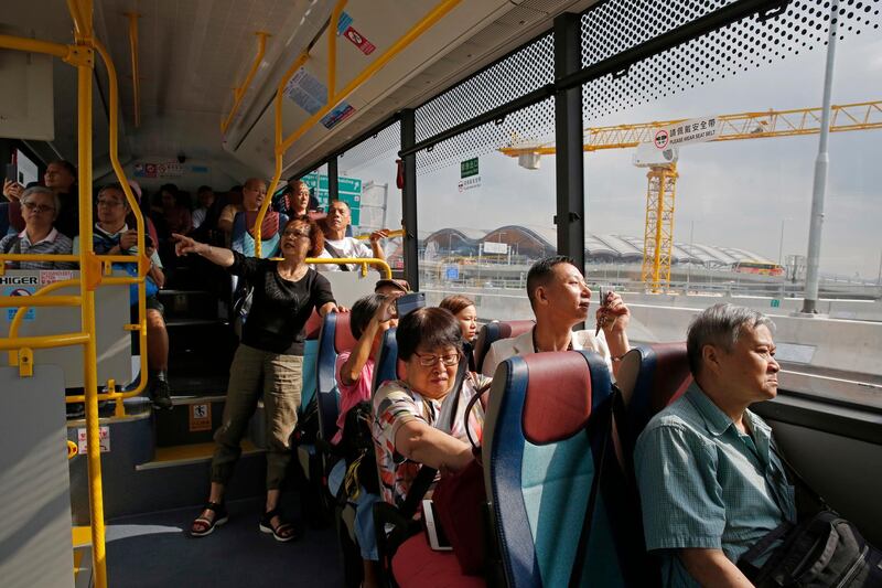 Passengers take the shuttle bus to cross the China-Zhuhai-Macau-Hong Kong Bridge during the first day operation of the world's longest cross-sea project. AP Photo