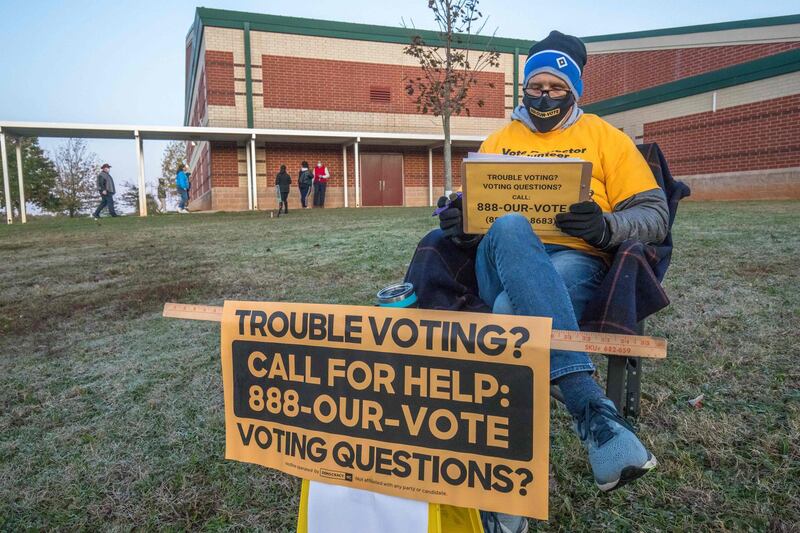 A volunteer with Democracy North Carolina sits to answer questions at Waddell Language Academy in Charlotte, North Carolina, shortly after the polls opened. AFP