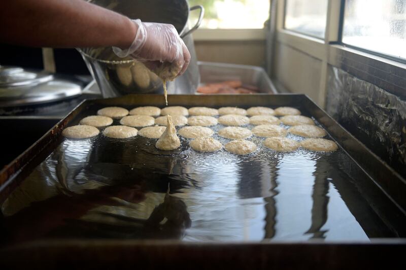 Saleh Al Halwachi, co-owner of Saleh Radhi Al Halwachi Sweets, makes Bahraini saffron and cardamom cakes known as khanfaroosh, at his shop in Jid Hafs village on the outskirts of the Bahraini capital, Manama.