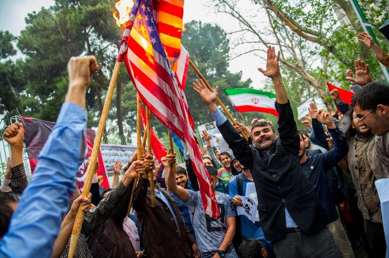 Iranians wave American and Iranian flags during an anti-U.S. demonstration outside the former U.S. embassy headquarters in Tehran, Iran, on Wednesday, May 9, 2018. U.S. President Donald Trump pulled out of the 2015 deal that put limits on Iran’s nuclear program in exchange for rapprochement with the West. Photographer: Ali Mohammadi/Bloomberg