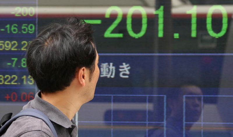 A man looks at an electronic stock board of a securities firm in Tokyo, Friday, Aug. 18, 2017. Japanâ€™s benchmark Nikkei 225 index lost 1 percent as Asian stocks sank Friday as big losses on Wall Street amid continuing U.S. political turmoil and a deadly van attack in Spain pressured global investor sentiment. (AP Photo/Koji Sasahara)