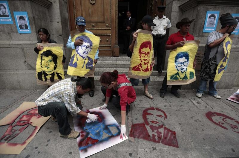 Activists spray paint images of people who went missing during the internal armed conflict at the entrance of the Congress building during a protest in Guatemala City. Jorge Dan Lopez / Reuters