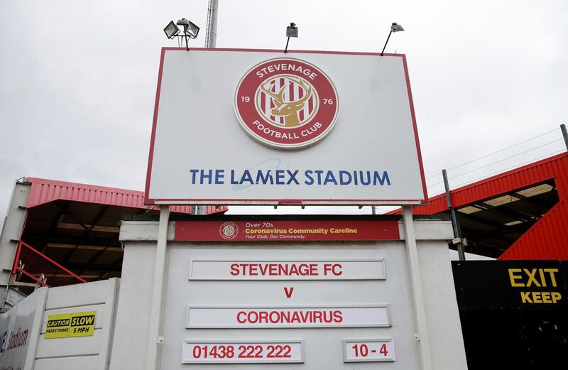 The Lamex Stadium, home of Stevenage football club, where the upcoming fixture board shows Stevenage FC v Coronavirus, Sunday March 29, 2020. Stevenage plays in the fourth tier of the English football league system, and all soccer games have been canceled until further notice. The COVID-19 coronavirus causes mild or moderate symptoms for many people, but for some, especially older adults and people with existing health problems, it can cause severe illness requiring hospital admission and has caused many deaths worldwide.(Adam Davy/PA via AP)
