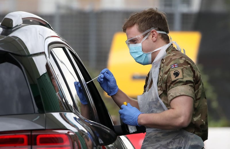 A soldier from 2 Scots Royal Regiment of Scotland  tests a key worker for the novel coronavirus Covid-19 at a drive-in testing centre at Glasgow Airport on April 29, 2020, as the UK continues in lockdown to help curb the spread of the coronavirus.  / AFP / POOL / Andrew Milligan

