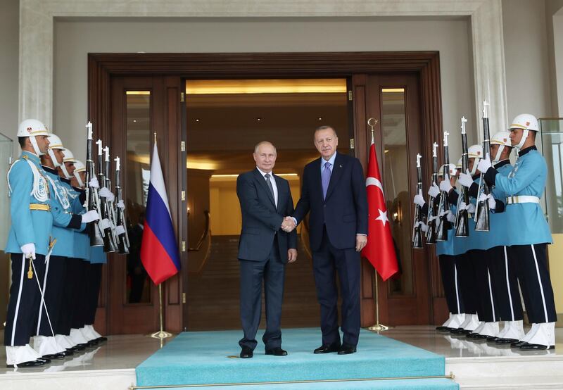 Turkish President Recep Tayyip Erdogan, right, and Russia's President Vladimir Putin shake hands as they inspect an honour guard during a welcome ceremony, in Ankara, Turkey.  AP