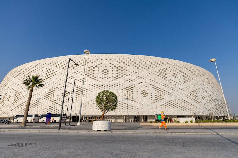 A worker passes by the Al Thumama Stadium in Doha that will host the World Cup later this year. Bloomberg