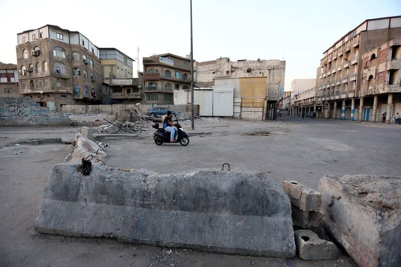 A man rides his motorcycle next to concrete blocks erected by Iraqi security forces to close a district as a part of restrictions against the spread of Covid-19 in central Baghdad, Iraq.  EPA