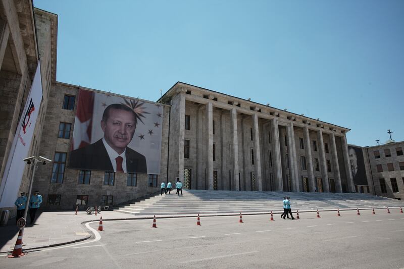 Giant portraits of President Recep Tayyip Erdogan, left, and Turkey's founder Mustafa Kemal Ataturk, right, hang outside the parliament building in Ankara. AP