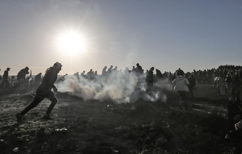 Palestinian protesters run through tear gas fumes during clashes with Israeli forces following a demonstration along the border with Israel east of Gaza CitY. AFP