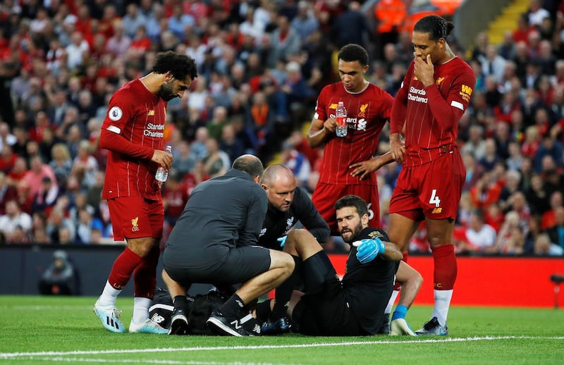 Liverpool goalkeeper Alisson Becker receives medical attention after sustaining an injury. Reuters