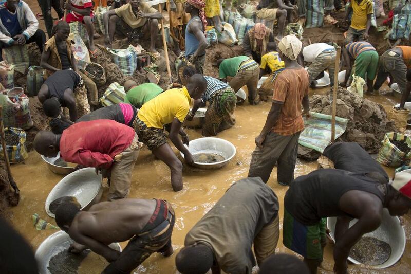 Prospectors wash extracted soil and small rocks as they pan for gold near the open-pit at the Ndassima gold mine. Siegfried Modola / Reuters