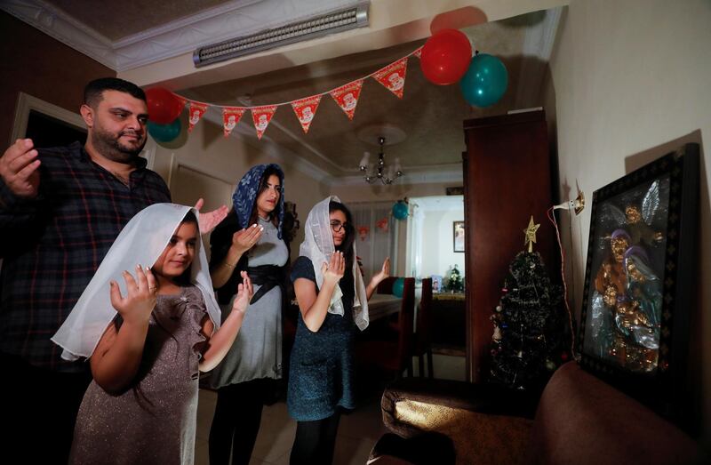 A Coptic family pray during Egypt's Coptic Christmas eve Mass in their home in Shubra El Kheima, Al Qalyubia Governorate, Egypt. Reuters