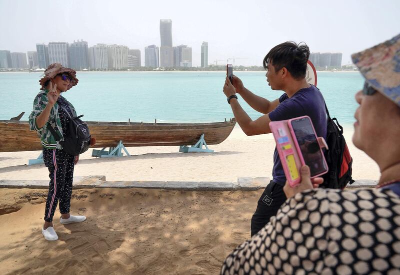 Abu Dhabi, United Arab Emirates, July 23, 2019.  Chinese tourists enjoy the sights at the Heritage Village, Corniche, in spite of the humid weather.
Victor Besa/The National
Section:  NA
Reporter: