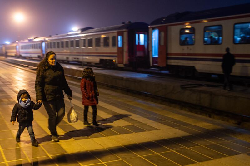 A woman walks with her children to spend the night in a train provided by the Turkish State Railways at the main station in Elazig, Turkey. Getty Images