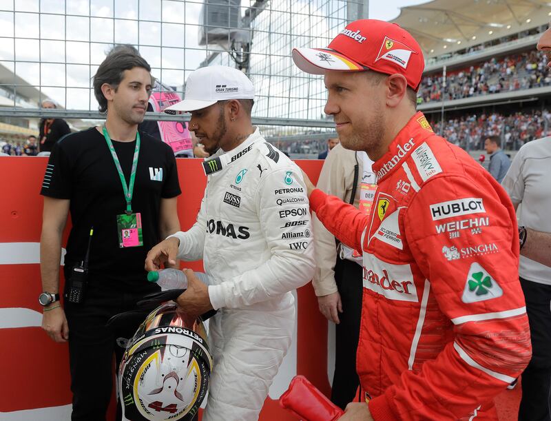 Mercedes driver Lewis Hamilton, of Britain, is congratulated by Ferrari driver Sebastian Vettel, right, of Germany, after Hamilton won the pole for the Formula One U.S. Grand Prix auto race at the Circuit of the Americas, Saturday, Oct. 21, 2017, in Austin, Texas. Vettel is starting third. (AP Photo/Darron Cummings)