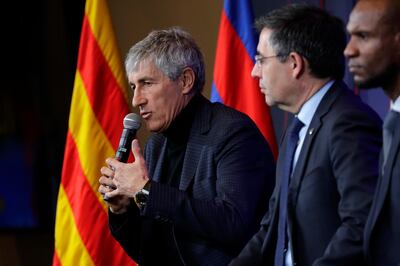 Soccer coach Quique Setien answers journalists during a news conference with FC Barcelona's President Josep Maria Bartomeu, center, and director of football Eric Abidal, right, after being officially introduced as the club's new coach at the Camp Nou stadium in Barcelona, Spain, Tuesday, Jan. 14, 2020. Barcelona made a rare coaching change midway through the season, replacing Ernesto Valverde with former Real Betis manager Quique Setien on Monday. (AP Photo/Emilio Morenatti)