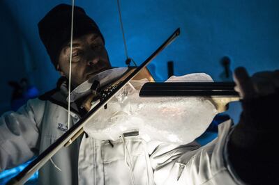 A musician perform with an ice violin during a concert in the "Ice Dome" on Presena Galcier, Tonale Pass, near Trento in northern Italy on January 17, 2018. When Tim Linhart started making instruments from ice they were more likely to explode with a bang than produce music, but things have come a long way since then. Today, the US-born artist is in charge of an ice orchestra playing a series of concerts at sub-zero temperatures in a vast, custom-built igloo high in the Italian Alps. 
 / AFP / Marco BERTORELLO
