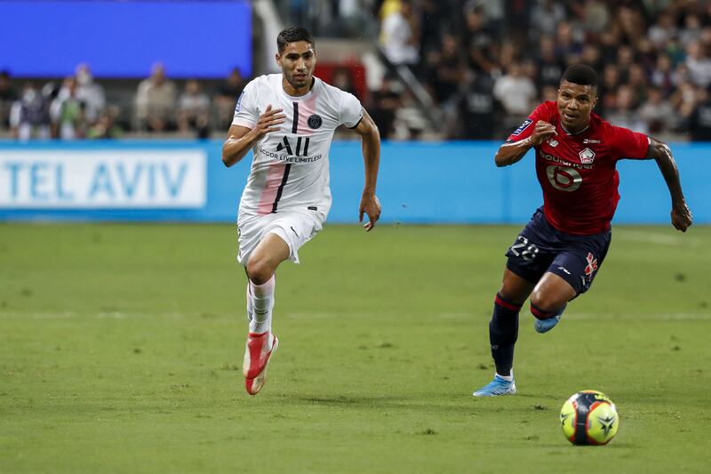Paris Saint-Germain's Moroccan defender Achraf Hakimi and Lille's defender Reinildo Mandava vie for the ball during the Trophee des Champions match against Lille.