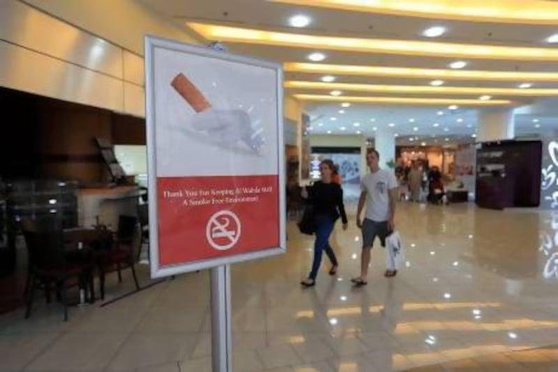 No smoking signs remind shoppers not to light up at Al Wahda Mall in Abu Dhabi, but some still try their luck in the cafes. Ravindranath K / The National