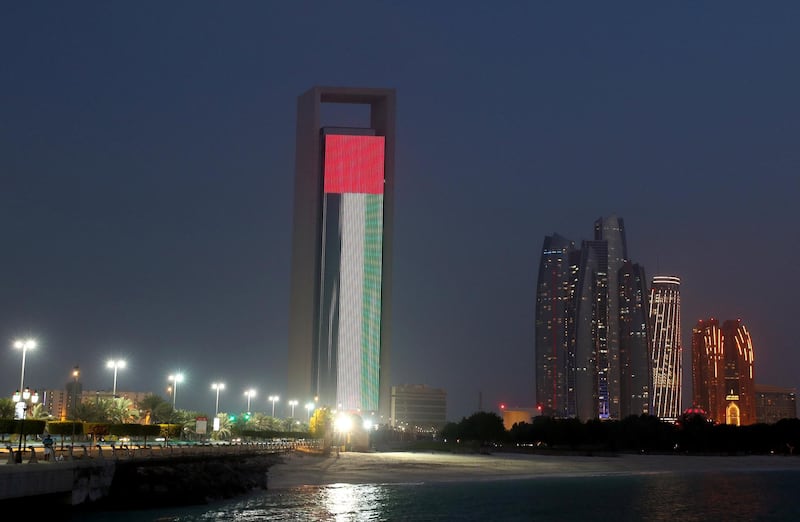 Abu Dhabi, United Arab Emirates - July 22, 2019: Adnoc head office is lit up with the UAE flag to celebrate Sheikh Mohamed bin Zayed's visit to China. Monday the 22nd of July 2019. Corniche, Abu Dhabi. Chris Whiteoak / The National