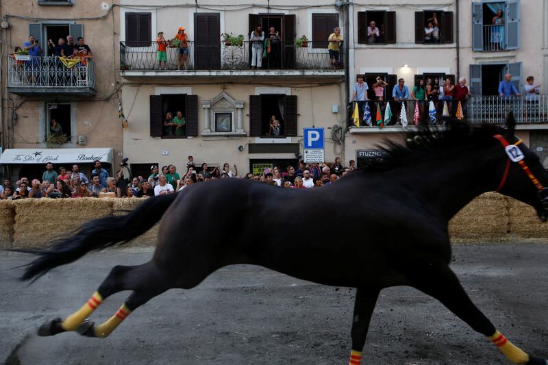 People watch the Palio di San Bartolomeo event from balconies.