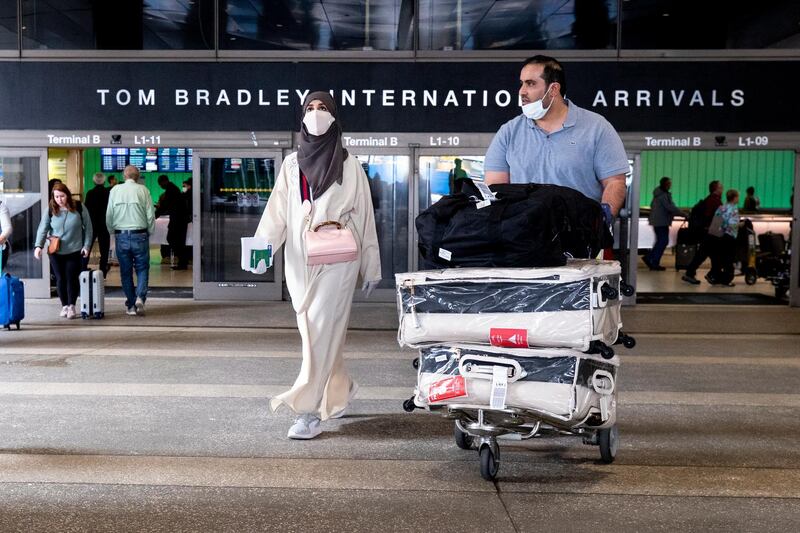 epa08281991 Passengers from Saudi Arabia wearing face masks exit the LAX Tom Bradley International Airport in Los Angeles, California, USA, 09 March 2020. Health measures have been taken to insure public areas of the Los Angeles airport are maintained cleaned. The spread of the Covid-19 - Coronavirus continues in Los Angeles County with officials announcing today two new cases.  EPA/ETIENNE LAURENT