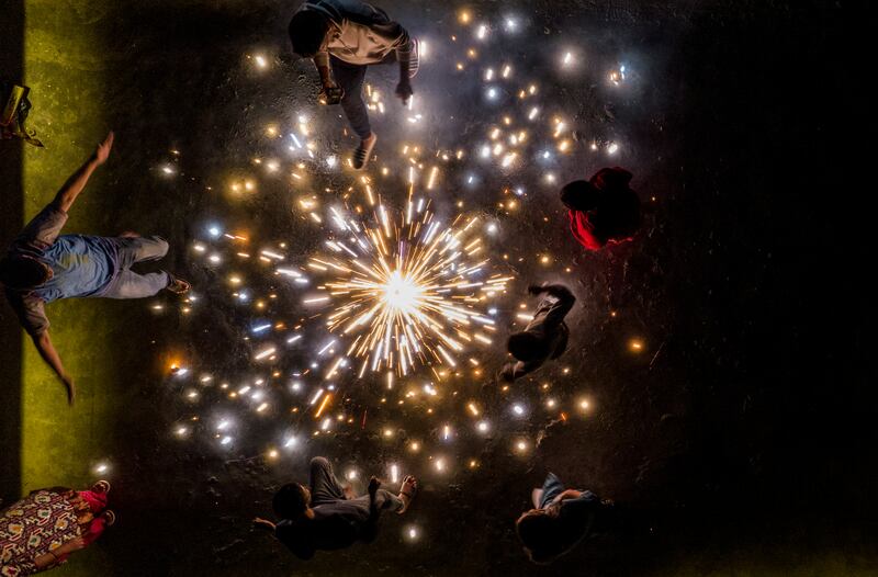 Family members play with firecrackers in Kathmandu. Diwali is known as the Tihar festival in Nepal. EPA