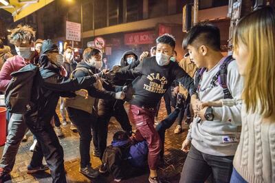 TOPSHOT - In this photo taken on February 9, 2016, an altercation takes place during clashes between protesters and police, later dubbed the "Fishball Revolution", in the Mongkok area of Hong Kong. Hong Kong's leading independence activist Edward Leung was jailed for six years on June 11, 2018 for his involvement in some of the city's worst protest violence for decades. The charges against Leung relate to his involvement in running battles with police over Lunar New Year in 2016 when protesters hurled bricks torn up from pavements and set rubbish alight in the commercial district of Mong Kok. / AFP / Terry WONG
