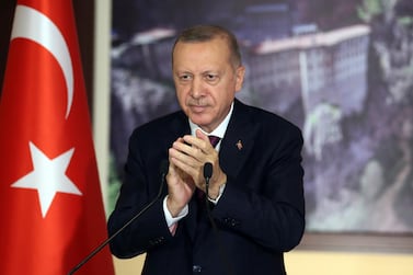 Turkey's President Recep Tayyip Erdogan applauds during a conference in Istanbul, Tuesday, July 28, 2020. Turkish lawmakers were making their final speeches Tuesday before voting on a bill that would give the government greater powers to regulate social media, in what human rights groups and the opposition have decried as a violation of free expression online. Hundreds of social media users have already been investigated and some arrested for their posts on the COVID-19 pandemic, opposition to Turkish military offensives in Syria or insulting Erdogan and other officials. (Turkish Presidency via AP, Pool)