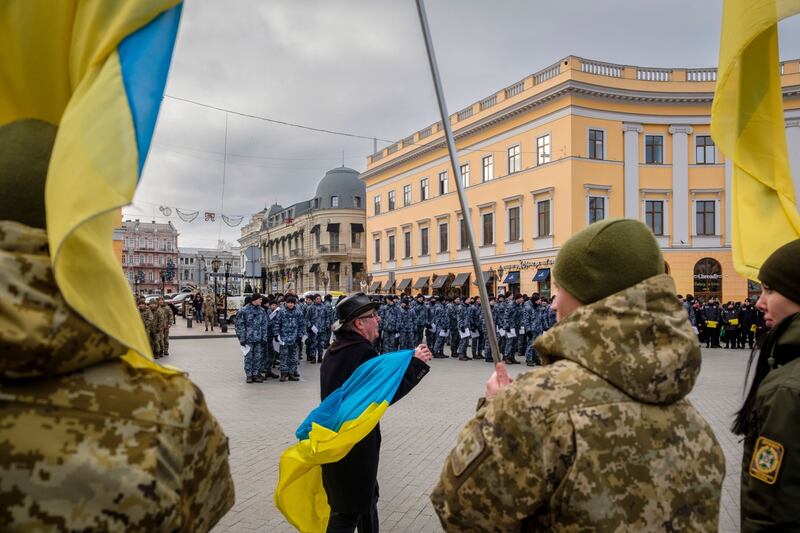 A member of the public waves a Ukrainian flag at a rally attended by soldiers and police in Odessa, Ukraine. Bloomberg