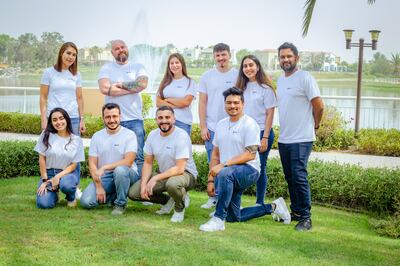 Growdash co-founders Enver Sorkun, kneeling second left, and Sean Trevaskis, kneeling second right, with the start-up's team in Dubai. Photo: Growdash
