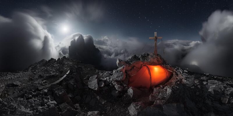 'Lavaredo's Gloria', Alex Wides: 'In this 360-degree panorama the moon illuminates the Tre Cime di Lavaredo (Three Peaks of Lavaredo, Italy), as well as the fog and cloud that surrounds the cross on top of Mount Paterno. A magnified shadow of the photographer and the cross is also cast onto the fog below, an optical phenomenon called a Brocken Spectre. These occur when the sun or moon is low in the sky and the observer is looking down into fog or cloud from an elevated position. The sun or moon projects a shadow on the antisolar or antilunar point and this is often surrounded by delicately coloured rings, called a glory, caused by the backscattering of light by small droplets.'