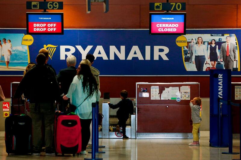 Passengers stand in front of closed check-in counters of Ryanair at Barcelona's El Prat airport in Spain. AFP